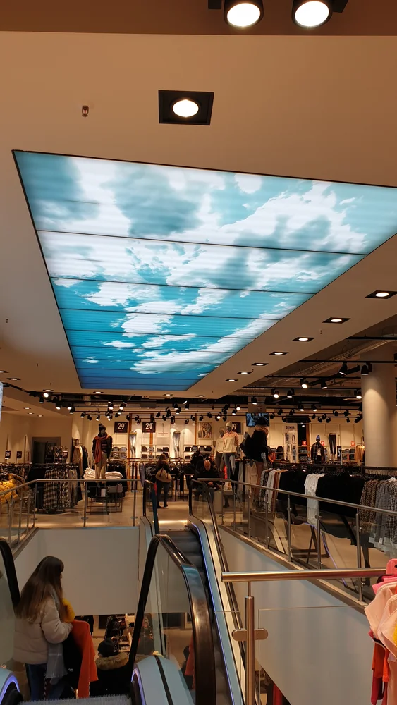 Lichtdecke mit Himmelmotiv über der Rolltreppe