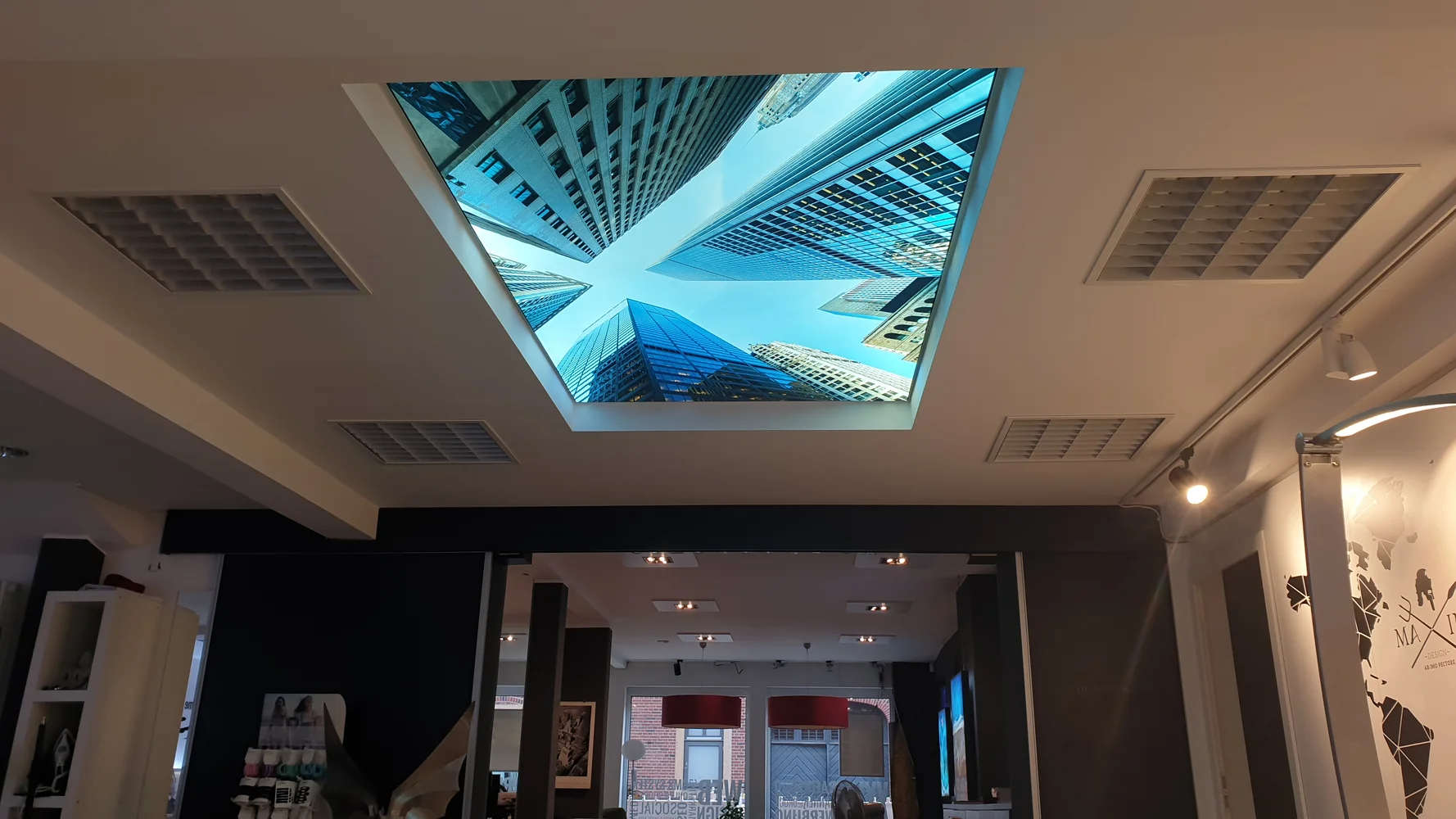 Lichtdecke mit Hochhausmotiv über dem Verkaufsraum